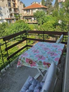 una mesa y sillas con una sombrilla floral en el balcón en Margo, en Sozopol