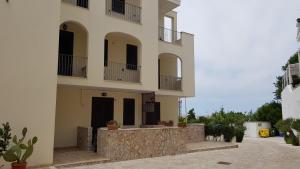 un grande edificio bianco con balconi e un cortile di Residence Catona a Otranto
