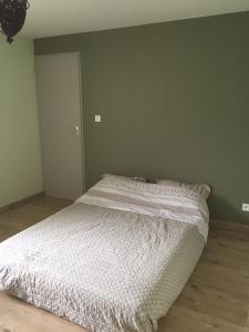 a bedroom with a large bed with white sheets at Domaine des Pierres Jumelles-balade à cheval-chambre d'hôtes Mayenne in Sainte-Gemmes-le-Robert