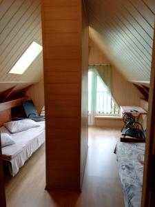 a attic bedroom with two beds and a window at Willa Kryształ in Stegna