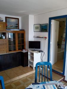 a living room with a tv and a desk with a computer at Rosas-Puig Rom -VISTA MAR in Roses