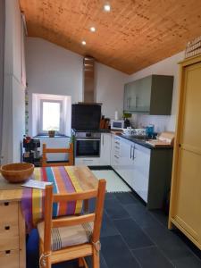 uma cozinha com armrios brancos e uma mesa e cadeiras em Quinta Quatro Ventos na Sert