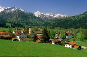 a town on a hill with mountains in the background at Pension Oberwirt in Fischbachau