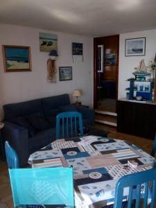 a living room with a table and a blue couch at Rosas-Puig Rom -VISTA MAR in Roses +18 photos