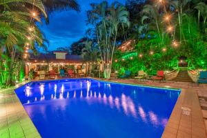 a swimming pool in a backyard at night with lights at Hotel Villas Lirio in Manuel Antonio