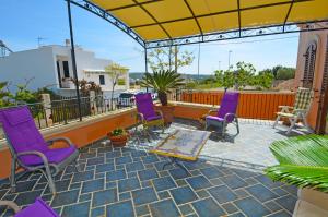 d'une terrasse avec des chaises violettes sur un balcon. dans l'établissement Casa Spano 2 - RosariaVacanze, à Patù