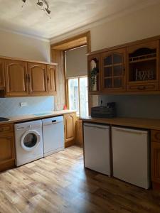 una cocina con lavadora y secadora. en Castle Gate Apartment en Jedburgh
