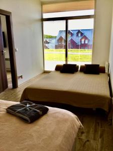 two beds in a room with a large window at Apartmán Horní Mísečky 437 in Horni Misecky