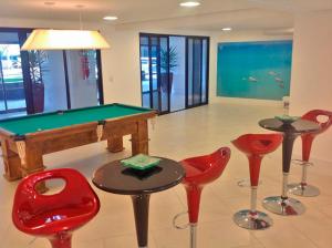 a room with a pool table and some red chairs at Landscape Beira Mar - 1804 Gold B in Fortaleza