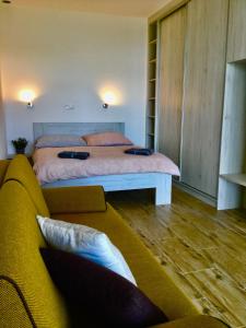a bedroom with a large bed and a couch at Apartmán Horní Mísečky 437 in Horni Misecky