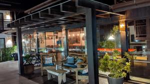 a store front with tables and chairs and plants at Pousada Rosa 08 in Praia do Rosa