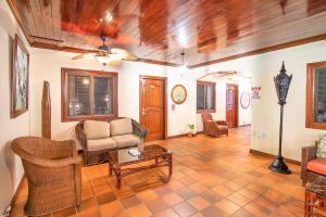 a living room filled with furniture and a large window at Hotel Villas Lirio in Manuel Antonio