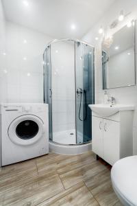 a bathroom with a shower and a washing machine at EMI Apartamenty in Świnoujście