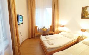 a hotel room with two beds and a television at Rezydencja Zamek in Krynica Zdrój