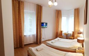 クリニツァ・ズドルイにあるRezydencja Zamekのベッド2台と窓が備わるホテルルームです。