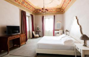 a bedroom with a white bed with a coffered ceiling at Vincafè in Alba