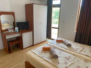 a bedroom with two beds and a desk and a mirror at Hotel Atanasov 1 in Primorsko