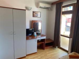a room with a desk with a computer and a window at Hotel Atanasov 1 in Primorsko