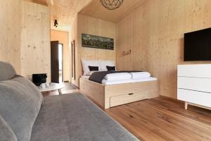 a bedroom with a bed and a tv and a couch at Water, Ski & Mountain Lodge in Kiefersfelden