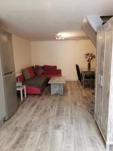 a living room with a red couch and a table at Palaz 1 - 2 Bedroom Garden Flat in Edmonton