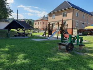 een park met een speeltuin met een glijbaan en een glijbaan bij Penzion a restaurace na Křižovatce in Polevsko