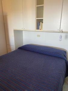 a bedroom with a blue bed with a cabinet at Ginevra SurfHouse in Palau