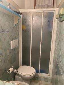 a bathroom with a toilet and a shower at Ginevra SurfHouse in Palau