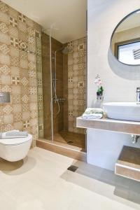 a bathroom with a toilet and a sink and a shower at On Board Luxury Studios in Sarti