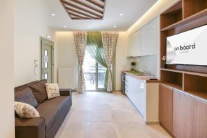 a living room with a couch and a kitchen at On Board Luxury Studios in Sarti