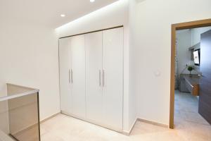 a large white wardrobe in a white room at On Board Luxury Studios in Sarti