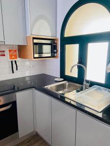 a kitchen with a sink and a microwave at Ocean Cliffs Apartments in Funchal +54 photos