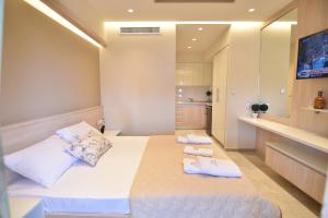 a bedroom with a large white bed with towels on it at On Board Luxury Studios in Sarti