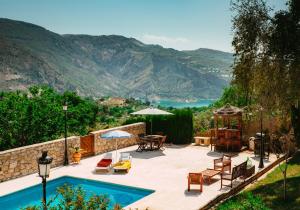 un patio con piscina, mesa y sillas en Casa Rural Alba Montis, en Güéjar-Sierra