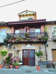 an old building with a balcony and potted plants at Posada de Seña in Seña