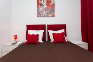 um quarto com duas almofadas vermelhas e brancas numa cama em COTE PORT em Cannes