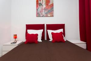 una camera da letto con 2 cuscini rossi e bianchi su un letto di COTE PORT a Cannes