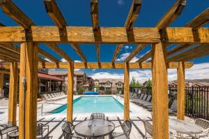 a pool with chairs and a wooden pergola at Bear Hollow Village in Park City