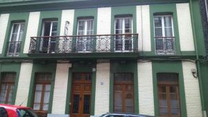 a green and white building with a balcony at Centro Tranquilo DOS BAÑOS DOS PATIOS in Gijón