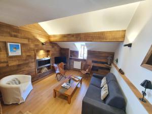 uma sala de estar com um sofá e uma mesa em Le repaire du vieux cerf em Le Monêtier-les-Bains