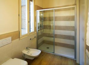 a bathroom with a shower and a toilet and a sink at Appartamenti Piazza Umberto I in Torri del Benaco