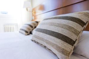 Una cama con dos almohadas encima. en LiebesNesterl Bergwirt - Boutique Hotel, en Köflach