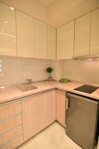 a kitchen with white cabinets and a sink at On Board Luxury Studios in Sarti