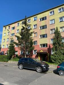 um carro preto estacionado em frente a um edifício em APARTAMENT OŚ. ZŁOTE 4B em Dzierżoniów