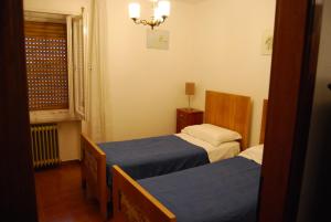 a small room with two beds and a window at Appartamento Ilaria in Vermiglio