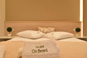 a bed with a blanket that reads hated on board at On Board Luxury Studios in Sarti