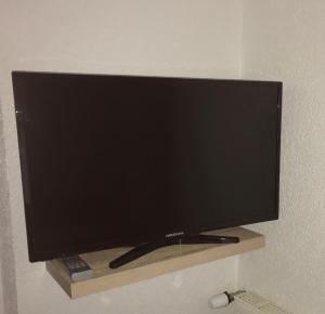 einen Flachbild-TV auf einem Regal in einem Zimmer in der Unterkunft Ferienwohnung Rottensteiner Sybille inclusiv Sommercard in Jerzens