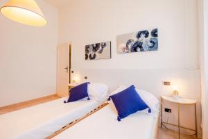 a living room with a white couch and two blue pillows at Forte 1013 in Forte dei Marmi