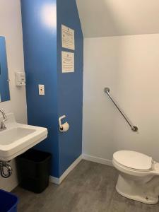 een badkamer met een wit toilet en een wastafel bij Auberge Internationale de Rivière-du-Loup in Rivière-du-Loup