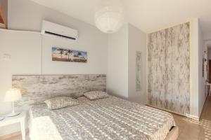una camera bianca con un letto in una stanza di Furnished Seafront Studio a Larnaka