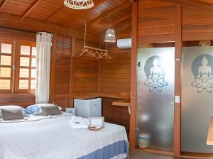 um quarto com uma cama num quarto com paredes de madeira em Pousada Villa del Lótus em Itarema